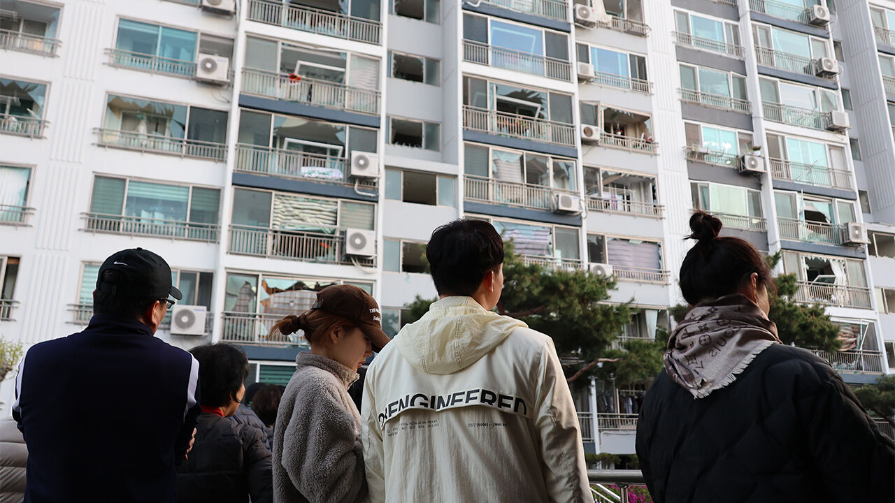 13일 오전 청주시 흥덕구 봉명동의 한 아파트 주민들이 폭발 사고 여파로 깨진 창문을 바라보고 있다.