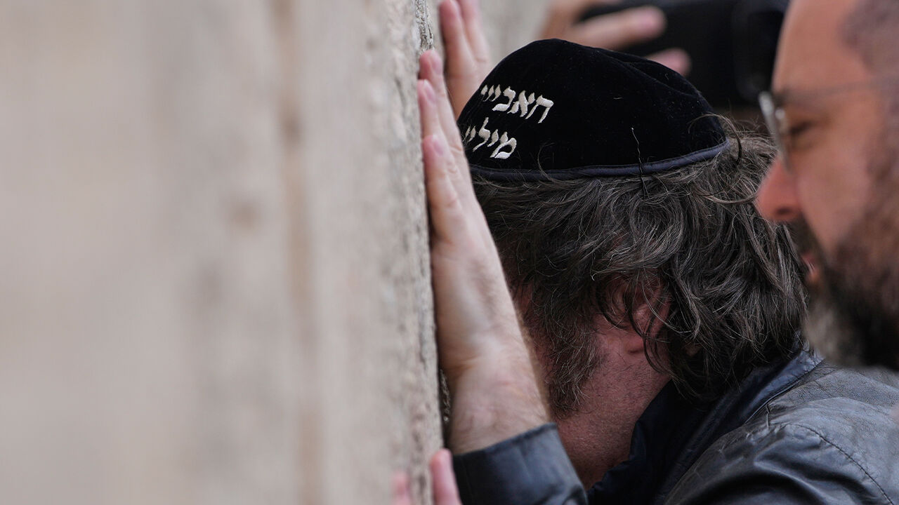 19일(현지시간) 이스라엘에 도착한 하비에르 밀레이 대통령이 히브리어로 자신의 이름이 수놓아진 유대인 두건을 착용하고 '통곡의 벽'에 손을 대고 기도하고 있다.