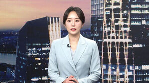 뉴스 스튜디오에서 밝은 하늘색 정장을 입고 뉴스를 진행하는 여성 앵커.