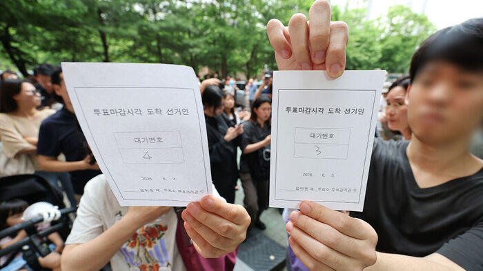 6·3 지방선거 본투표일인 3일 서울 송파구 잠실2동 6투표소에서 투표용지 부족으로 대기하던 한 유권자가 마감시간 후 대기번호표를 들어 보이고 있다 