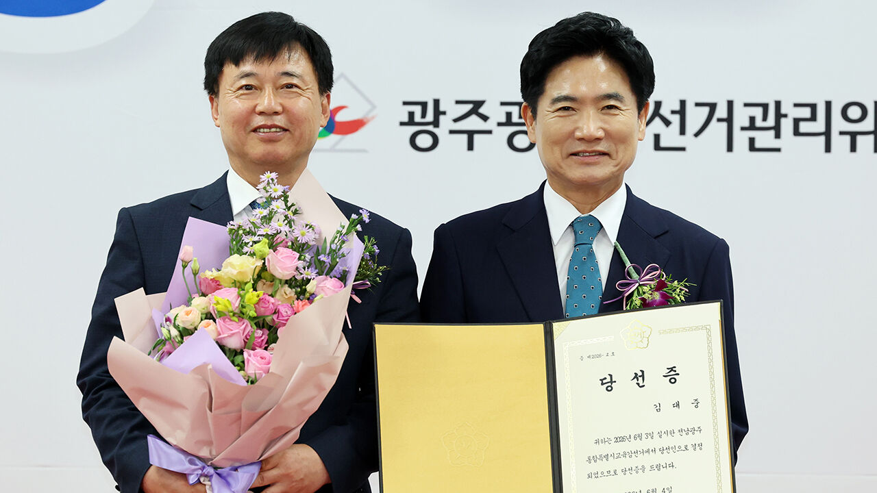 김대중 전남광주통합특별시 교육감 당선인이 4일 광주광역시선거관리위원회에서 장용기 위원장으로부터 당선증을 받고 기념 촬영하고 있다 (사진=연합뉴스)