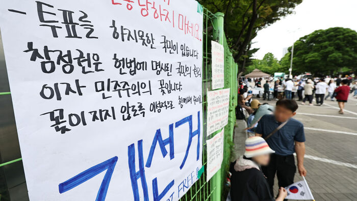 '잠실 개표소 봉쇄 시위'가 계속되고 있는 7일 서울 송파구 올림픽공원 핸드볼경기장 출입구 앞에 재선거를 요구하는 문구 등이 적힌 종이가 붙어있다. (사진=연합뉴스)