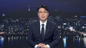 안경을 쓴 남성 앵커가 정장을 입고 서울 야경을 배경으로 뉴스를 진행하고 있다.
