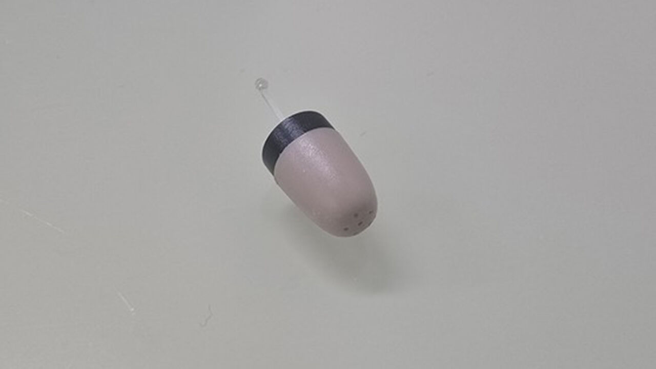 Miniature earphone worn by a client