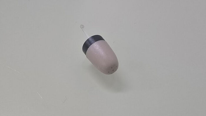 Miniature earphone worn by a client