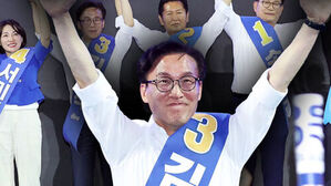 기호 3번 어깨띠를 두른 남성이 두 팔을 들어 환호하는 모습