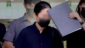마스크를 쓰고 서류철로 얼굴을 가린 채 이동하는 인물과 관계자들