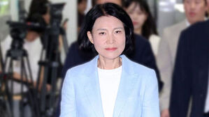 하늘색 재킷을 입고 정면을 응시하는 단발머리 여성