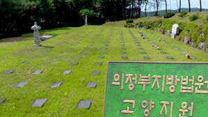 의정부지방법원 고양지원 표지판과 잔디가 깔린 야외 묘지 전경