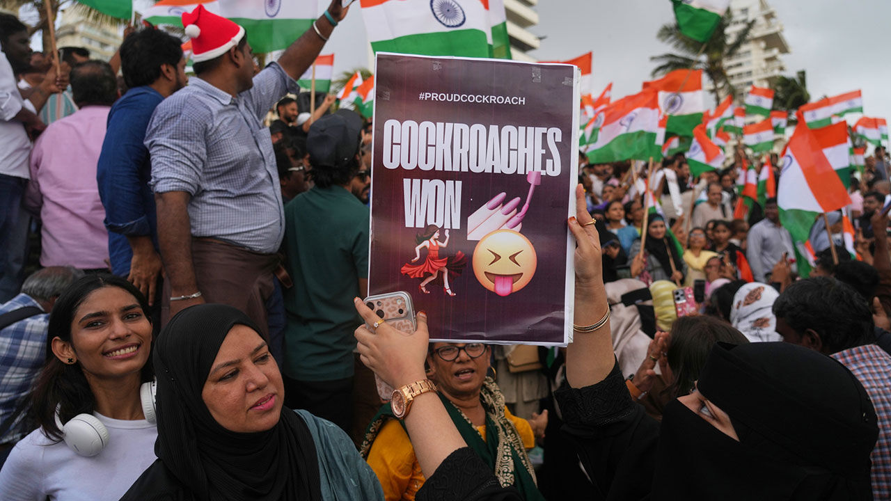 A protester holds a sign amid the resignation of India's education minister.