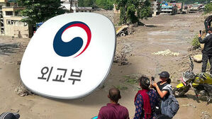 외교부 로고와 수해 현장을 바라보는 사람들과 진흙탕 피해 현장