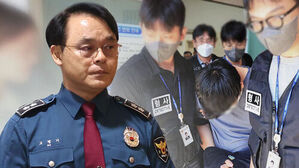 경찰 제복을 입은 남성과 형사들이 피의자를 이송하는 모습