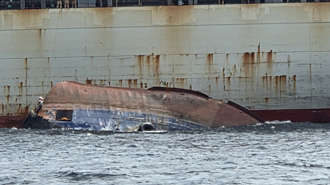 A capsized tugboat off the coast of Busan and a passing cargo ship conducting rescue operations (Photo courtesy of the Busan Coast Guard, Yonhap News)