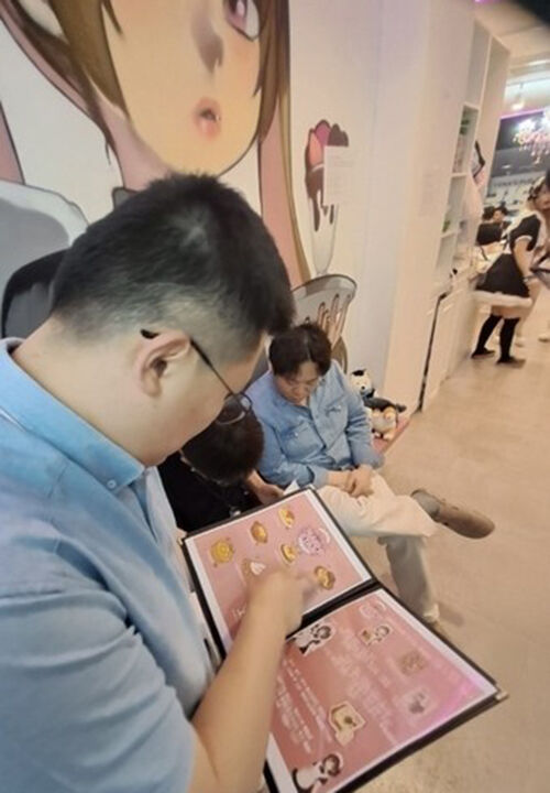 Mapo-gu official checking a menu at a concept cafe (Photo provided by Mapo-gu, Yonhap News)