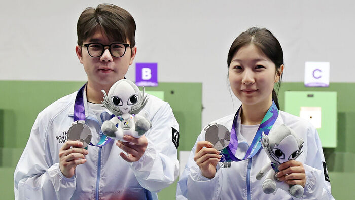 South Korean silver medalists Ban Hyo-jin (right) and Park Ha-jun hold up their medals during the award ceremony for the 10m air rifle mixed team event at the 2026 Aichi-Nagoya Asian Games held at the Aichi Prefectural General Shooting Range in Japan on the 22nd. (Photo: Yonhap News)