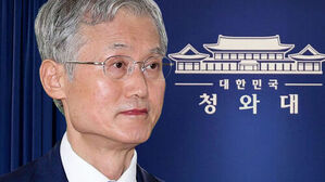 대한민국 청와대 로고를 배경으로 안경을 쓴 남성의 상반신