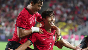 붉은색 축구 국가대표 유니폼을 입고 밝게 웃으며 기뻐하는 손흥민과 동료 선수들