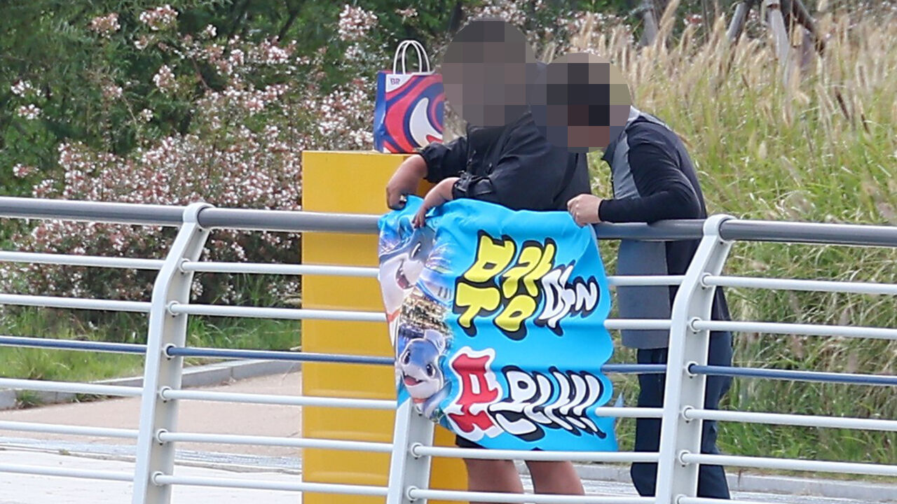 29일 부산 동구 북항친수공원에서 한 시민이 '부캉아 또 온나'라고 적힌 현수막을 들고 있다. (사진=연합뉴스)
