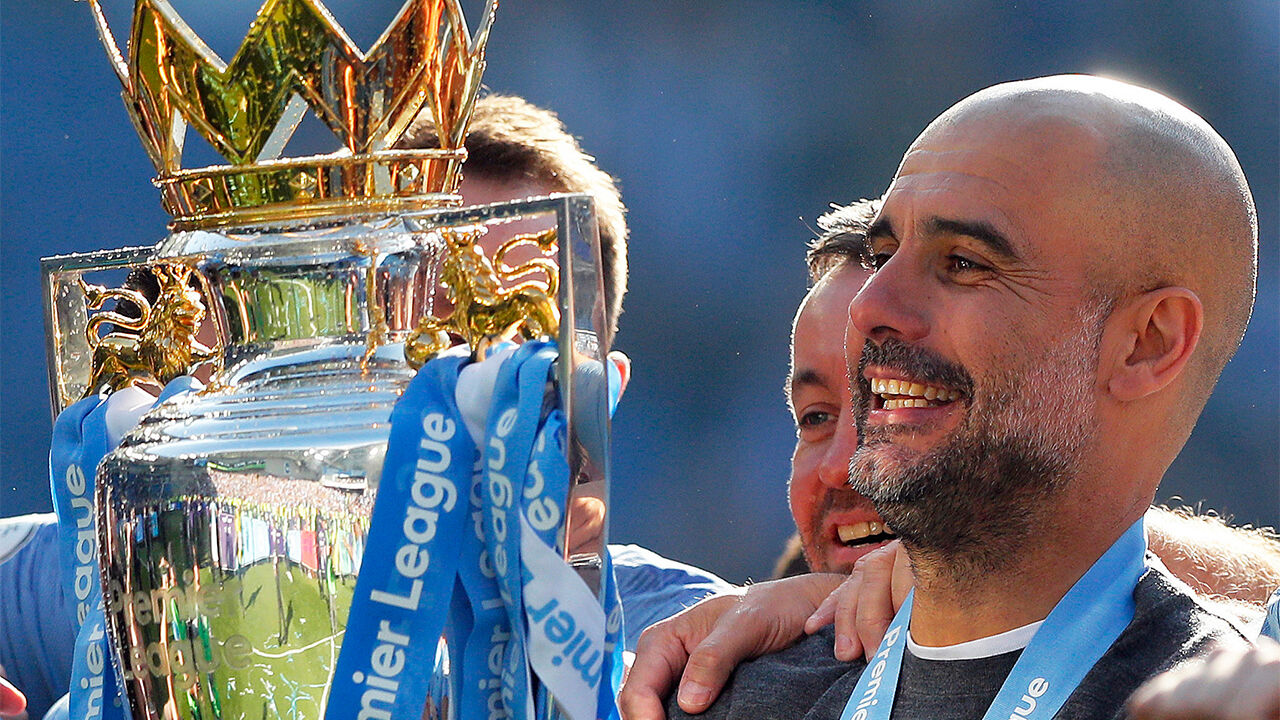 Manager Guardiola lifting the championship trophy
