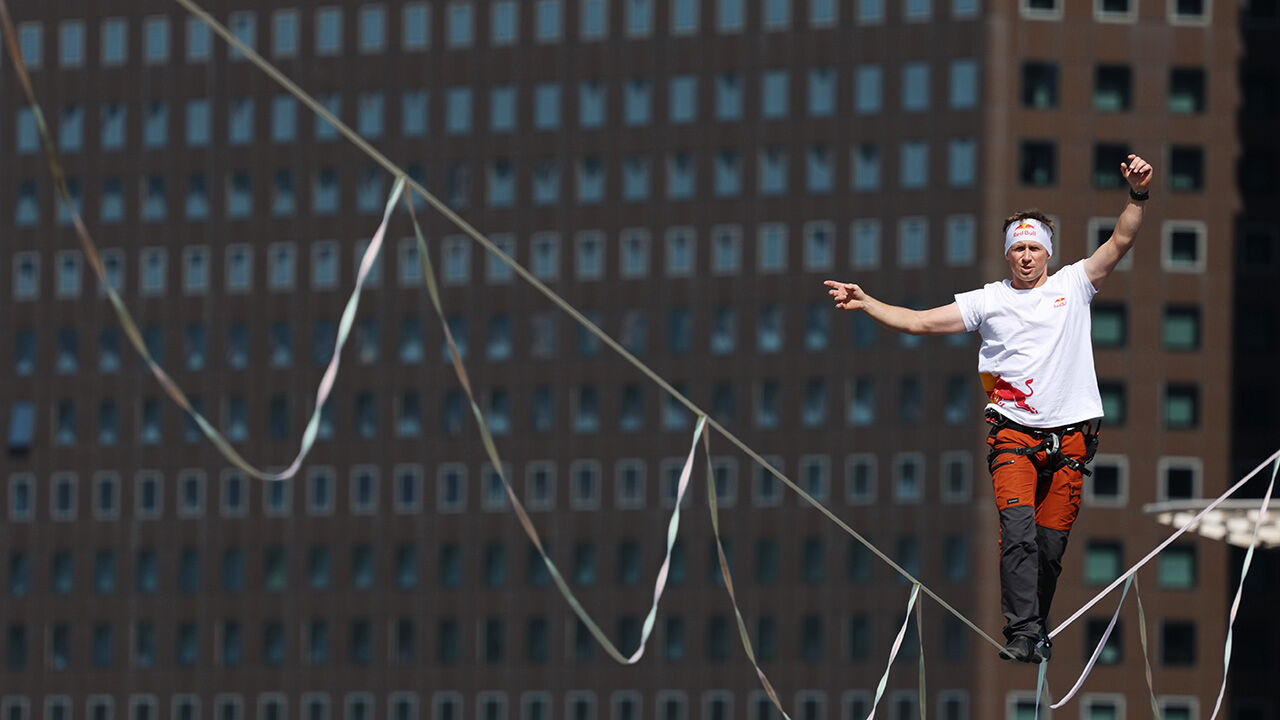 Slackline athlete Jaan Roose performs stunts in the air above Sejong-daero, in front of Cheonggye Plaza in Seoul, on the 1st, walking and showcasing various skills while balancing on a tightrope. (Photo: Yonhap News)