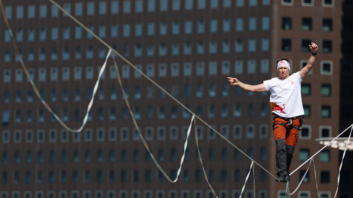 Slackline athlete Jaan Roose performs stunts in the air above Sejong-daero, in front of Cheonggye Plaza in Seoul, on the 1st, walking and showcasing various skills while balancing on a tightrope. (Photo: Yonhap News)