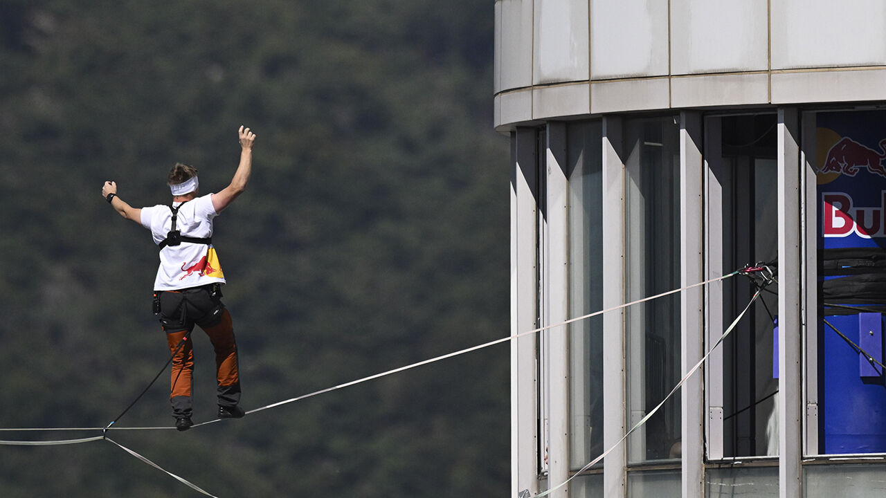 Slackline athlete Jaan Roose performs stunts in the air above Sejong-daero, in front of Cheonggye Plaza in Seoul, on the 1st, walking and showcasing various skills while balancing on a tightrope. (Photo: Yonhap News)