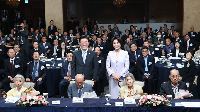 President Lee Jae-myung and First Lady Kim Hye-kyung pose for a commemorative photo after presenting cheongnyeojang, a cane made of goosefoot stalk, and bouquets to centenarians at the 30th Senior Citizens' Day ceremony held at a hotel in Seoul on October 2. (Photo: Yonhap News)