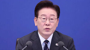 파란색 배경 앞 마이크 앞에서 발언하는 이재명 대표