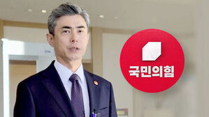 국민의힘 로고를 배경으로 서 있는 정점식 의원