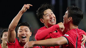 붉은 유니폼을 입은 축구 선수들이 환하게 웃으며 기뻐하는 모습