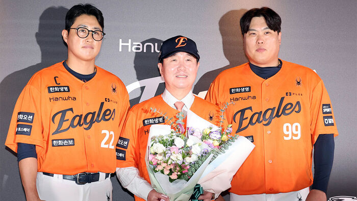Newly appointed Hanwha Eagles manager Ryu Ji-hyun receives a bouquet of flowers and poses for a commemorative photo with Ryu Hyun-jin and Chae Eun-seong at an inauguration ceremony held at Daejeon Hanwha Life Ballpark in Jung-gu, Daejeon, on the afternoon of the 16th. (Photo: Yonhap News)