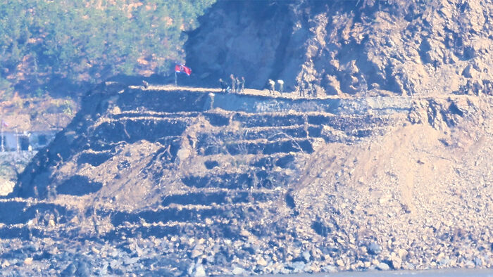 North Korean soldiers carry out border fortification work, including the construction of tactical roads and barbed-wire fences, in the border area of Gaepung County, Hwanghae Province, North Korea, as seen from Ganghwa County, Incheon, on October 22.
