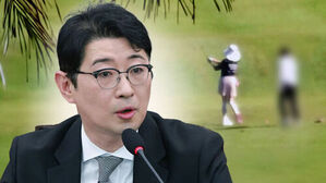 마이크 앞에 앉아 발언하는 안경 쓴 남성과 배경의 골프장 인물들