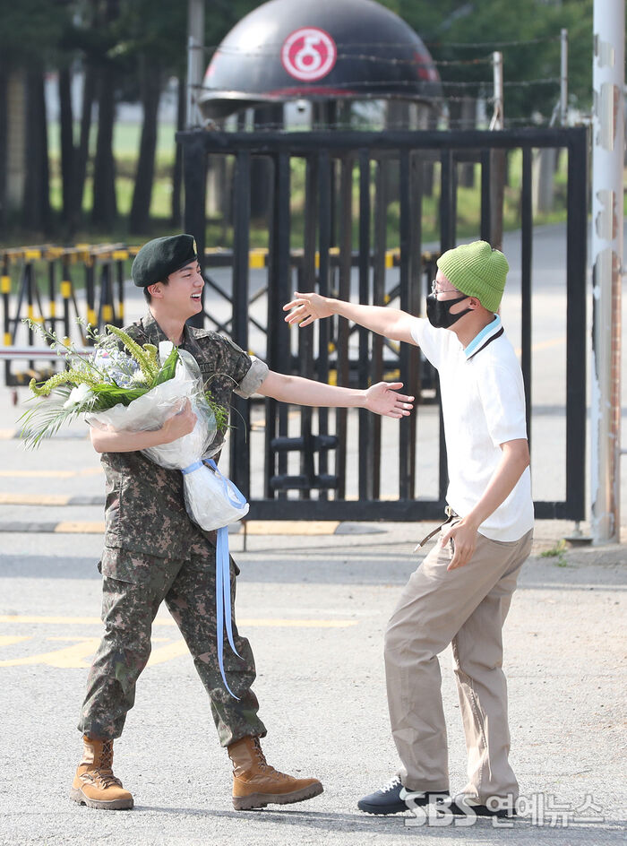 Jin smiles as he greets J-Hope after completing his military service