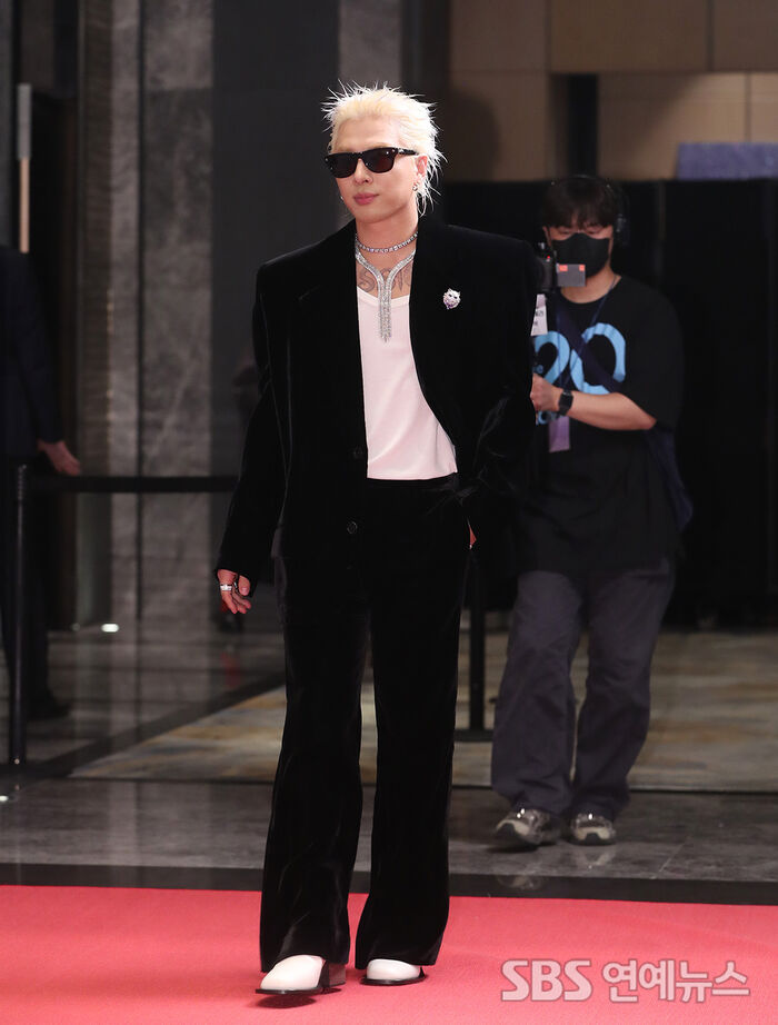Taeyang shows off statement shades at the campaign photo wall in Seoul