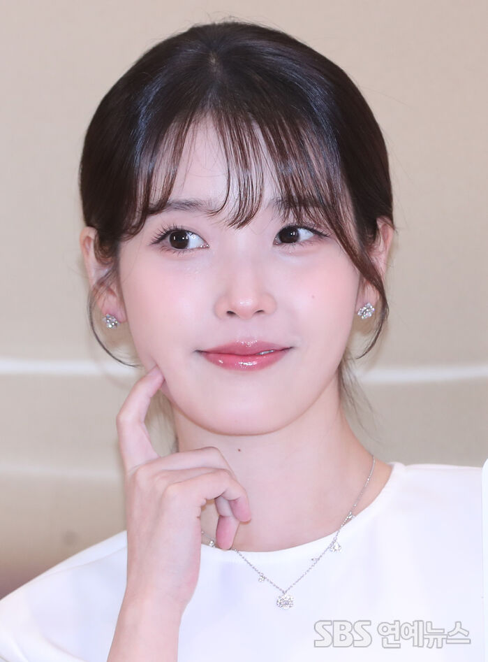IU Serves Juicy Cheek-Poke Aegyo at Seoul Beauty Photo Wall